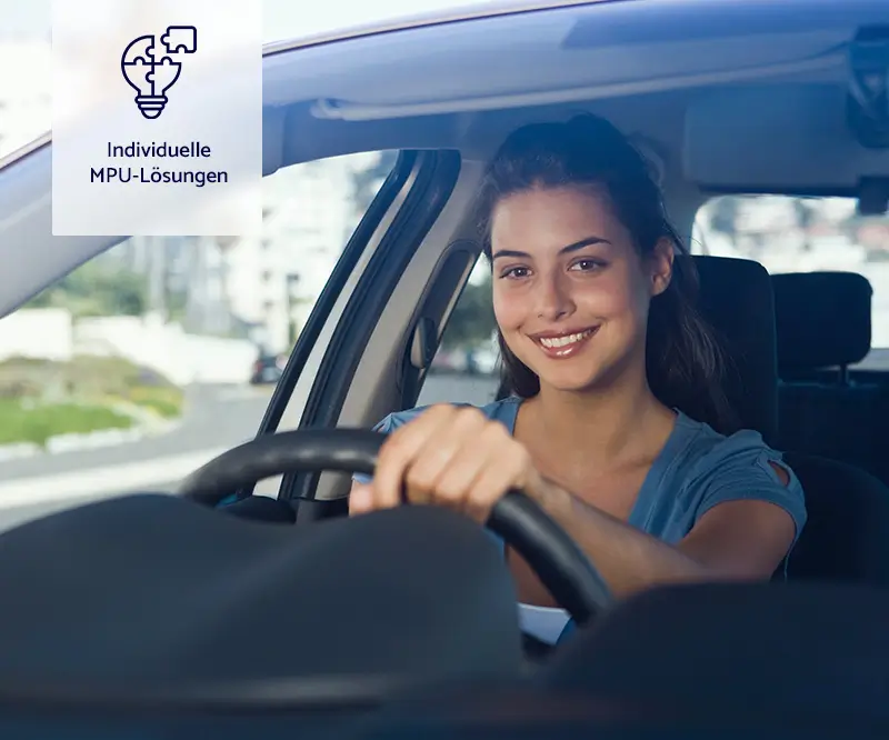 Das Bild zeigt eine junge Frau, die lächelnd hinter dem Lenkrad eines Autos sitzt. Sie fährt auf einer Straße, und durch das Fenster sind unscharf Gebäude und Grünflächen zu sehen. Die Frau wirkt entspannt und glücklich, was auf eine erfolgreiche Fahrt oder eine positive Erfahrung hinweisen könnte. In der oberen linken Ecke des Bildes befindet sich ein Icon mit einem Puzzleteil, das in eine Glühbirne passt, sowie der Text „Individuelle MPU-Lösungen“.